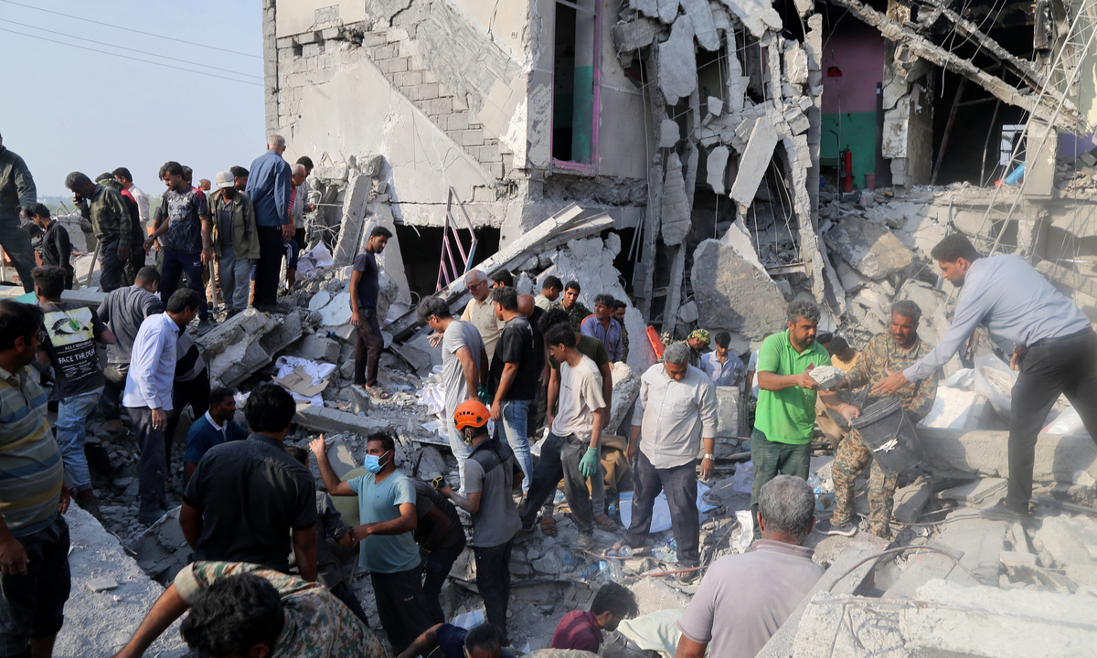 Archival photograph, 28 February 2026: rescuers search the rubble of the Shajareh Tayyebeh Primary School in Minab, Hormozgan province, Iran. Photograph: Abbas Zakeri / Mehr News Agency via Wikimedia Commons, CC BY 4.0, cropped.