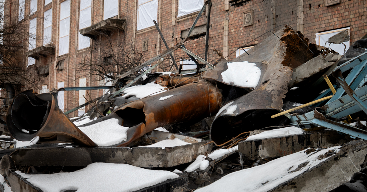 Twisted pipes and rubble covered in snow in front of a damaged brick building at the Darnytsia combined heat and power plant in Kyiv, February 2026.