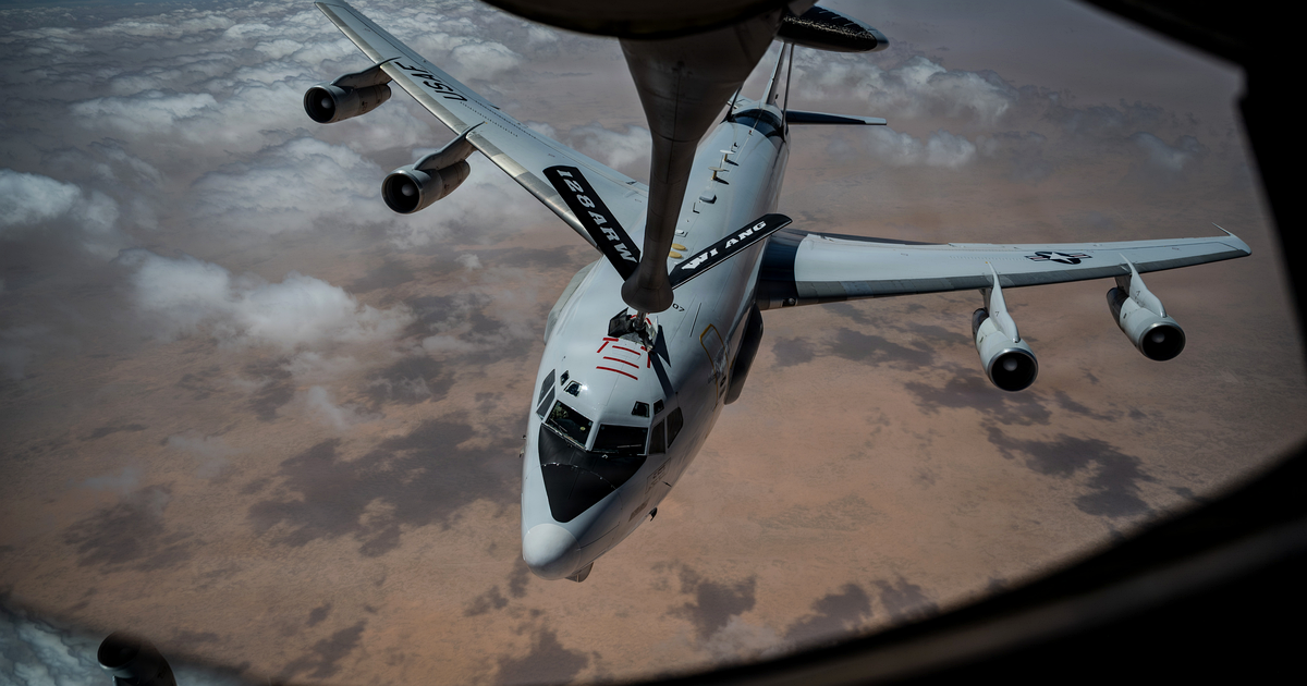A U.S. Air Force E-3 Sentry airborne warning and control aircraft, seen from a KC-135 Stratotanker's boom window, refuels over desert during Operation Epic Fury. U.S. Air Force photograph, via DVIDS and Wikimedia Commons, public domain.