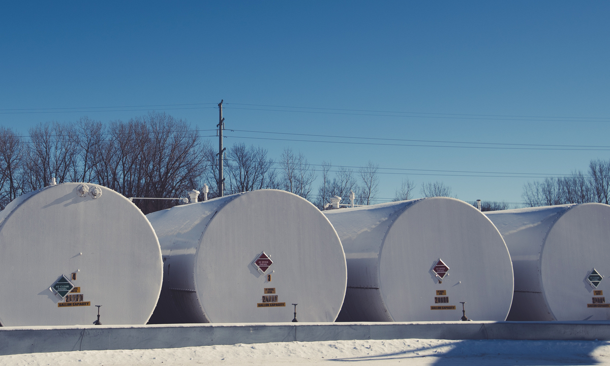Four white fuel storage tanks on snow under a blue sky in Faribault, Minnesota, with diamond signs reading #2 clear diesel and #2 dyed diesel. Photograph: Tony Webster / Wikimedia Commons, CC BY 2.0.
